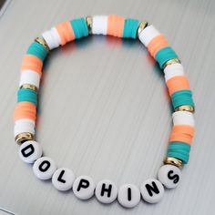 This Is A Miami Dolphins Beaded Bracelet In The Dolphins Colors Aqua, Orange And White. A Fun Bracelet To Wear Alone Or Stacking With Other Bracelets. These Bracelets Are Made With A Sturdy Elastic Cord Available In Multiple Sizes. Unisex Bracelets Size Guide: 5” - Kids 6” - Small 7” - Average Adult 8” - Large Thank You For Visiting My Store. Small Business Bracelet, Inspo Bracelets, Sea Beads, Make Clay Beads, Pony Bead Bracelets, Clay Bracelets, Clay Bead Necklace, Beaded Braclets, Homemade Bracelets