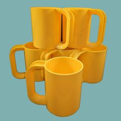 five yellow coffee mugs stacked on top of each other