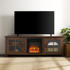 a flat screen tv sitting on top of a wooden entertainment center next to a fire place