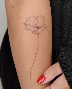 a woman's arm with a flower tattoo on the left side of her arm