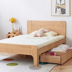 a wooden bed with two drawers underneath it in a child's playroom or bedroom