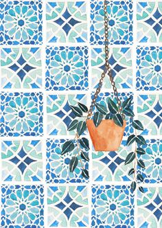 an orange potted plant hanging from a chain on a blue and white tile wall