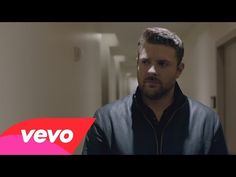 a man standing in a hallway wearing a black jacket