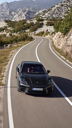 a black sports car driving down the road