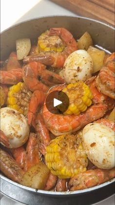 a pan filled with shrimp and potatoes on top of a stove