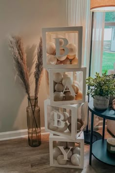 a stack of letters sitting on top of a table next to a vase with flowers in it