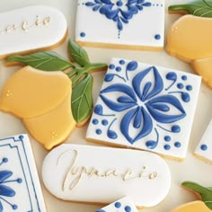 cookies decorated with blue and yellow designs on a white tablecloth that says verano