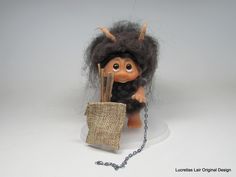 a troll doll holding a sack and chain