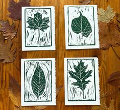 four leaf prints are placed on a wooden surface