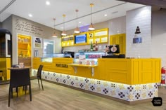 the interior of a coffee shop with yellow cabinets