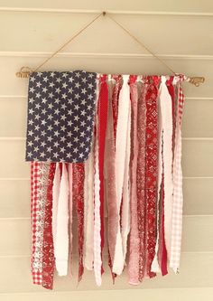 an american flag hanging on a wall with red, white and blue ribbons attached to it