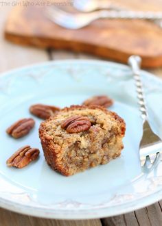 a piece of cake sitting on top of a blue plate next to pecans and a fork