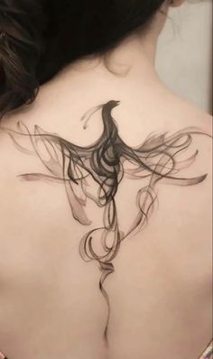 the back of a woman's neck with a bird tattoo on it