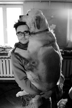 a man holding a large dog in his arms