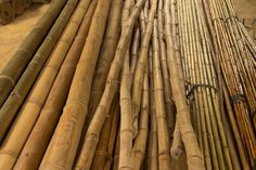 many bamboo poles are stacked together in a warehouse