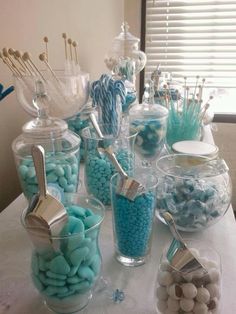 a table topped with lots of candy and candies on top of glass containers filled with lollipops