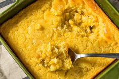 a green casserole dish with a spoon in it