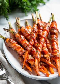 some carrots are on a white plate with sauce