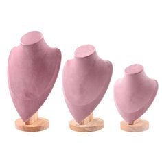 three pink mannequins on wooden bases, one is shaped like a heart