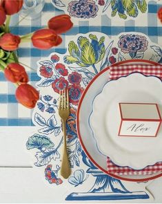 a place setting with red and blue flowers