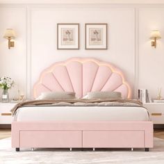 a pink bed with a shell shaped headboard and foot board in a white room