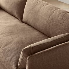 a brown couch sitting on top of a hard wood floor