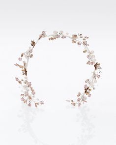 a headpiece with flowers and leaves on it's side, against a white background