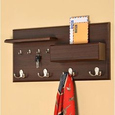 a coat rack with three hooks and two coats hanging on it's sides next to a wall