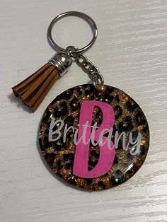 a keychain with the letter b on it and a tassel attached to it