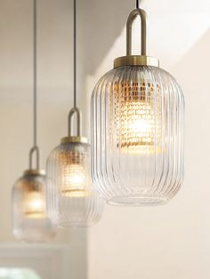 three glass pendant lights hanging from a ceiling