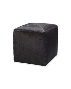 a black square ottoman sitting on top of a white floor