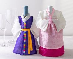 two wine bottles are decorated with colorful ribbons