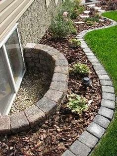 a brick wall next to a window in a yard