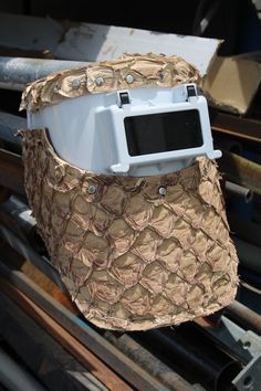 a white and brown hat sitting on top of a piece of wood