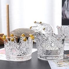 two clear glass crowns sitting on top of a table