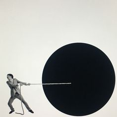 a man pulling a giant black object with a rope