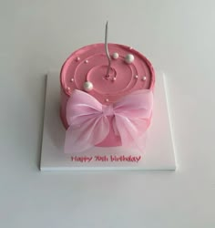 a birthday cake with pink icing and white pearls