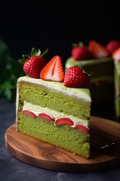 a slice of green cake with strawberries on top and another piece in the background