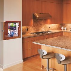 a kitchen with wooden cabinets and marble counter tops