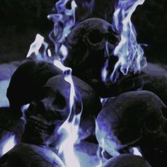 there are many skulls with blue flames in the background