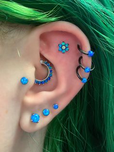 a woman with green hair and piercings on her ear