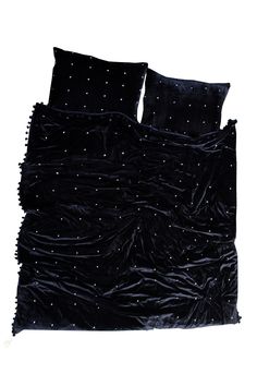 a bed with black velvet sheets and pillows on top of each other, in front of a white background