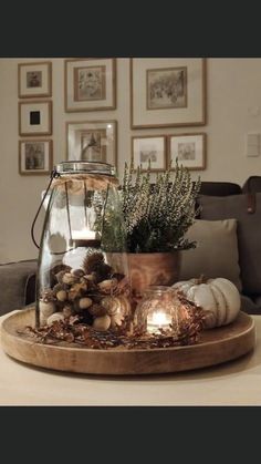 a table topped with a glass vase filled with plants and other things on top of it