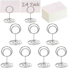 twelve metal circles with paper holders on each side and two small white cards in the middle