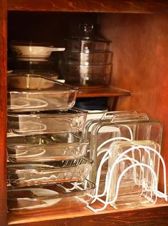 an open cabinet filled with glass dishes and bowls