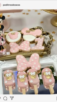 minnie mouse cake pops and mickey mouse cupcakes on a table with other decorations