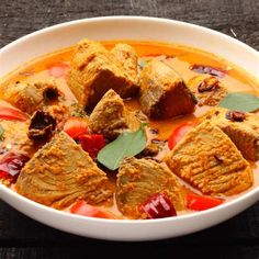 a white bowl filled with food on top of a wooden table