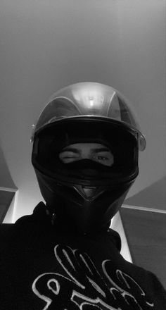 black and white photograph of a person wearing a motorcycle helmet