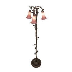 an antique style floor lamp with three pink glass shades on the top and one light in the middle