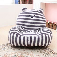 a large stuffed bear sitting on top of a chair in a room with pink walls